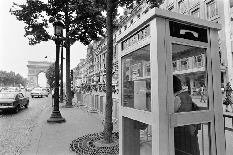 Une cabine téléphonique rouge classique, emblématique des rues des années 80.