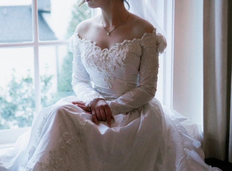 Une robe de mariée vintage, pliée avec soin, évoquant un héritage sentimental précieux