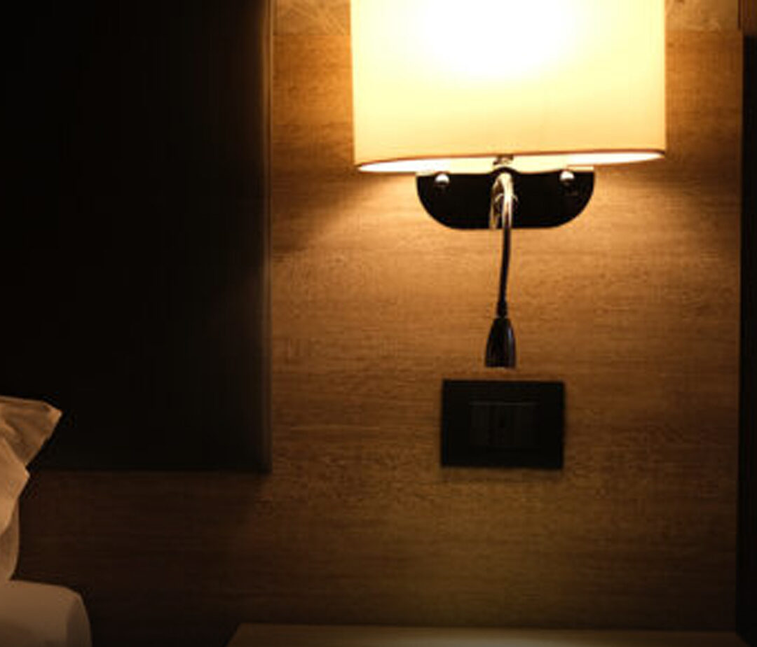 Femme dormant paisiblement dans un lit d'hôtel, une lueur douce provenant de la salle de bain