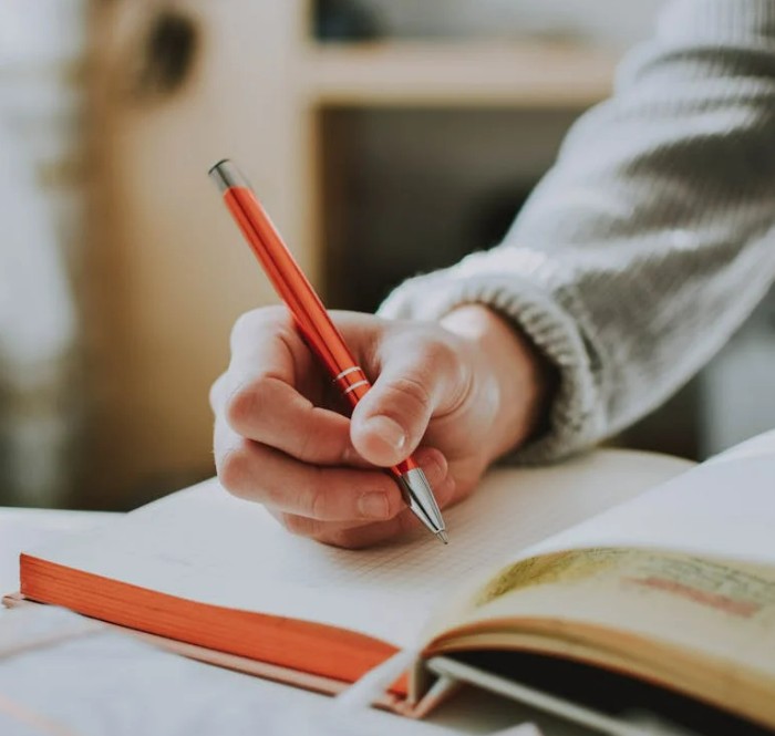 Mains en train d'écrire, l'une avec la main droite, l'autre avec la gauche