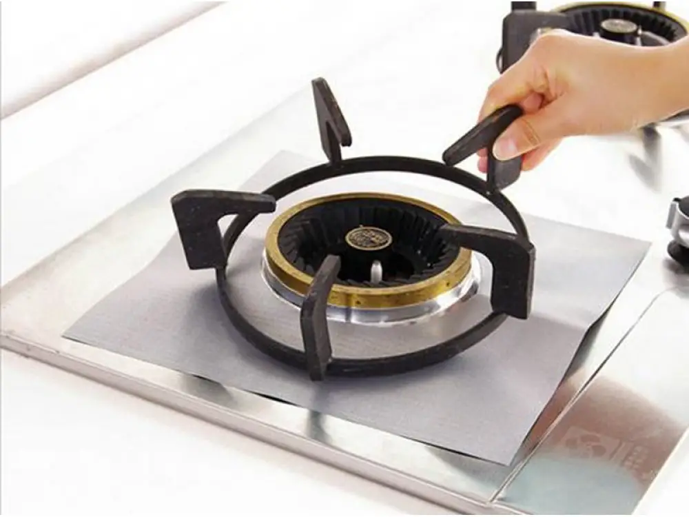 Grilles de cuisinière sales posées à côté d'éponges et de produits de nettoyage naturels