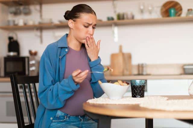 Personne se touchant la langue avec une expression de dégoût
