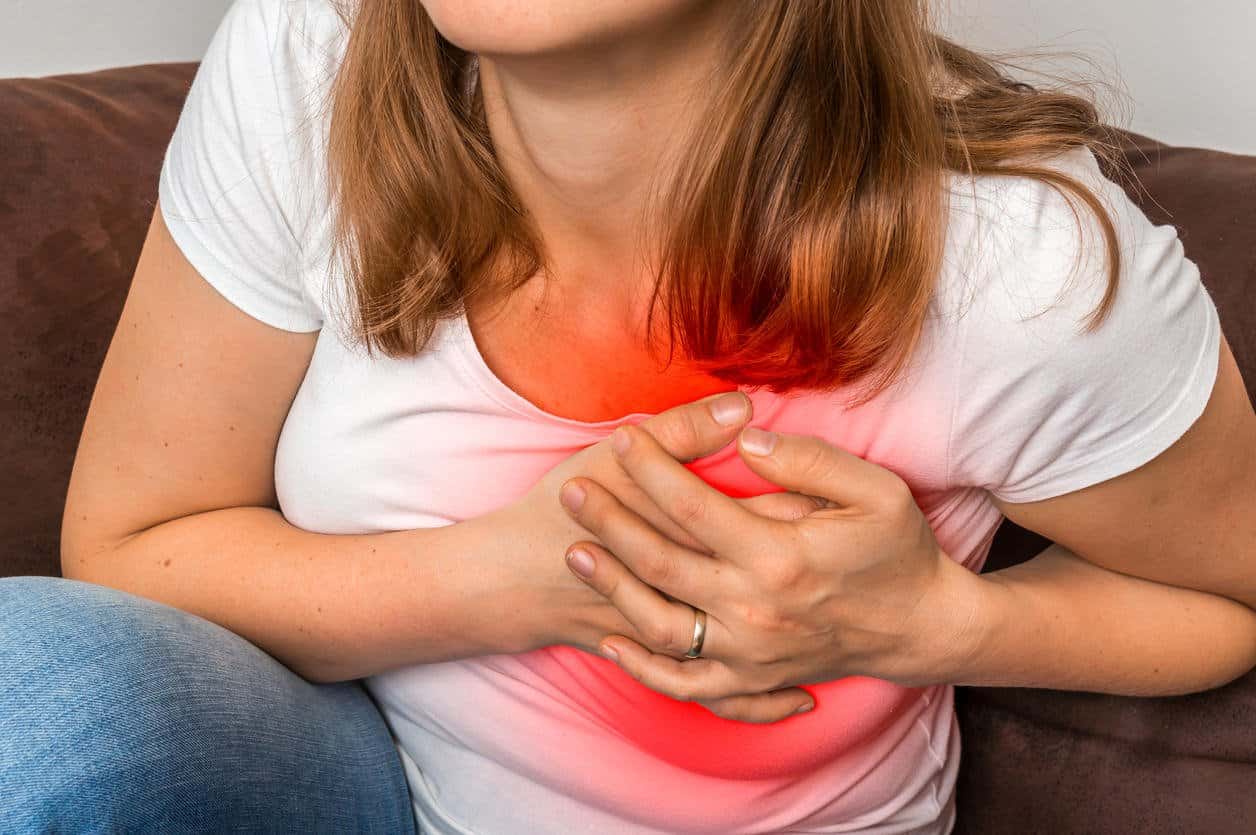 Jeune femme se tenant la poitrine avec une expression inquiète