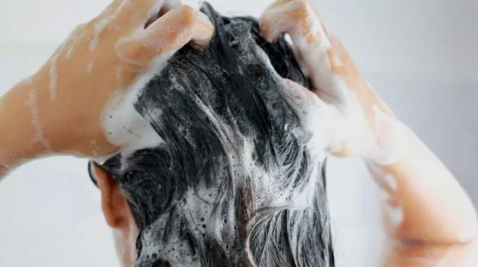 Femme se lavant les cheveux sous la douche