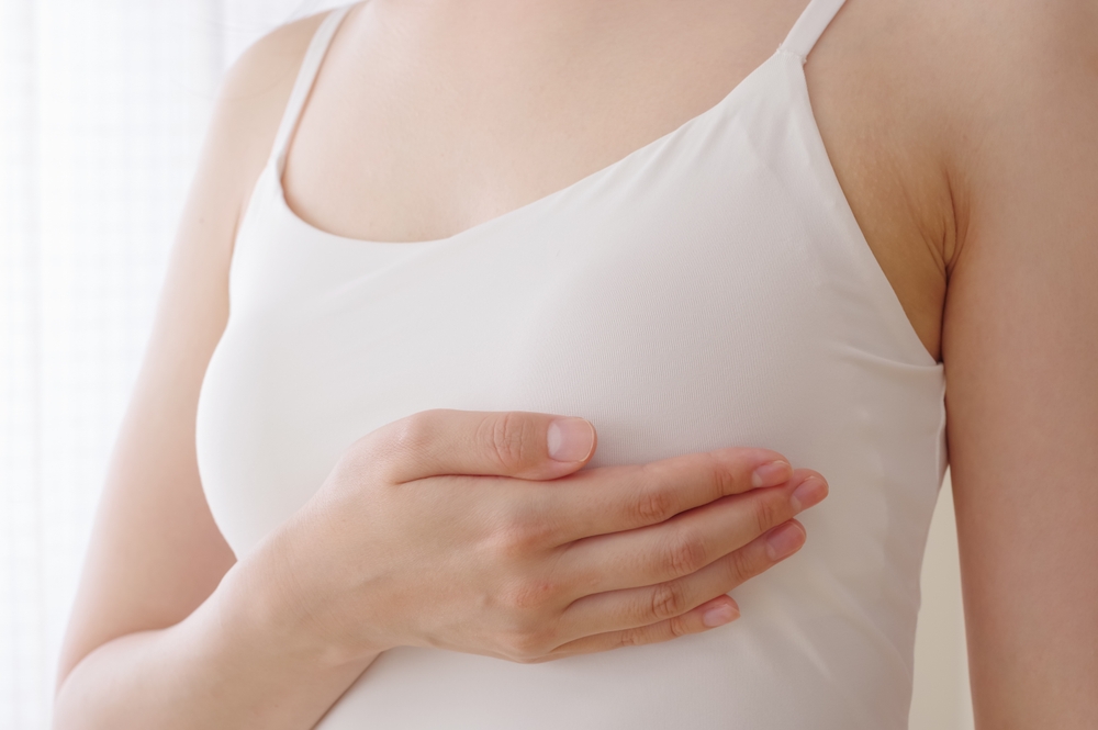 Femme active et souriante en tenue de sport, levant les bras en signe de victoire