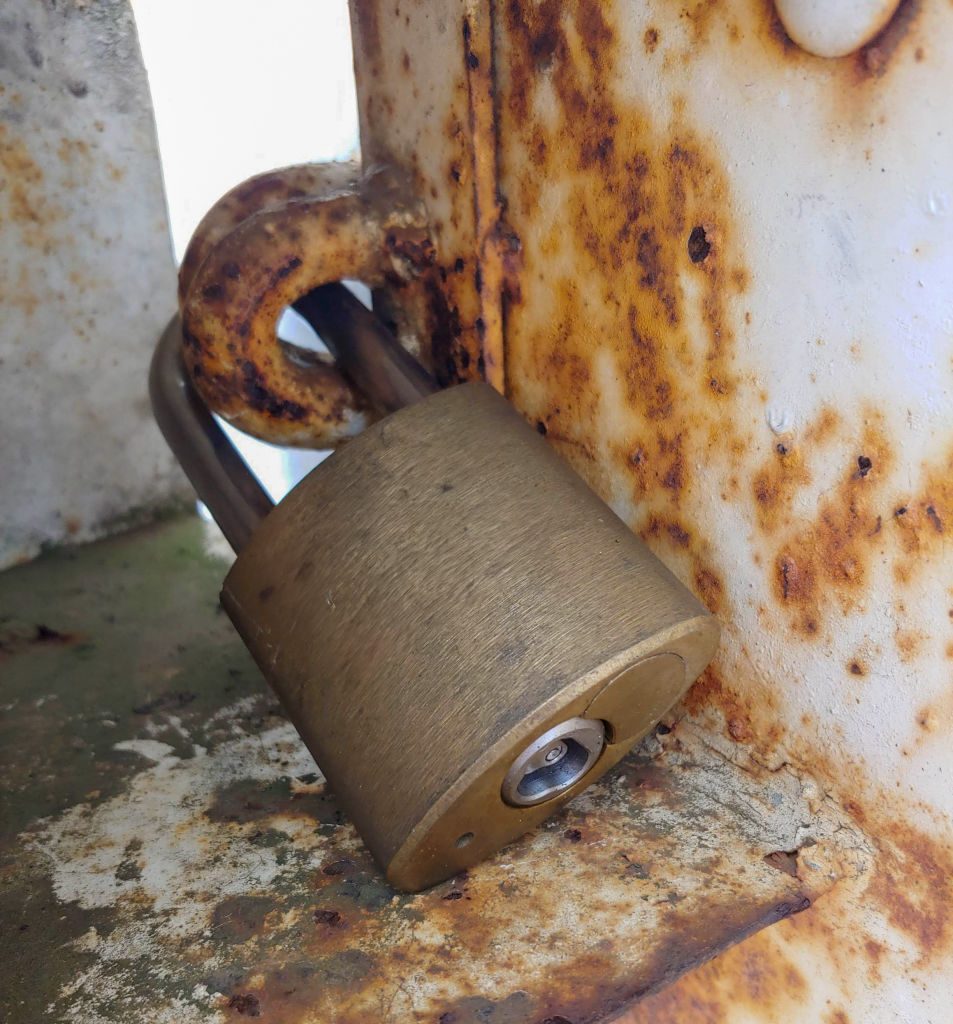 Personne utilisant un lubrifiant en spray sur le trou d'un cadenas