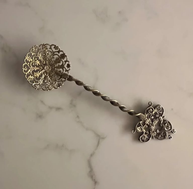 Cuillère à bonbons posée sur un napperon, détail