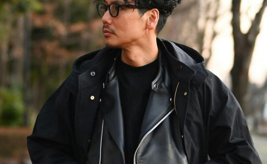 Ensemble de vêtements noirs stylés disposés sur un fond neutre