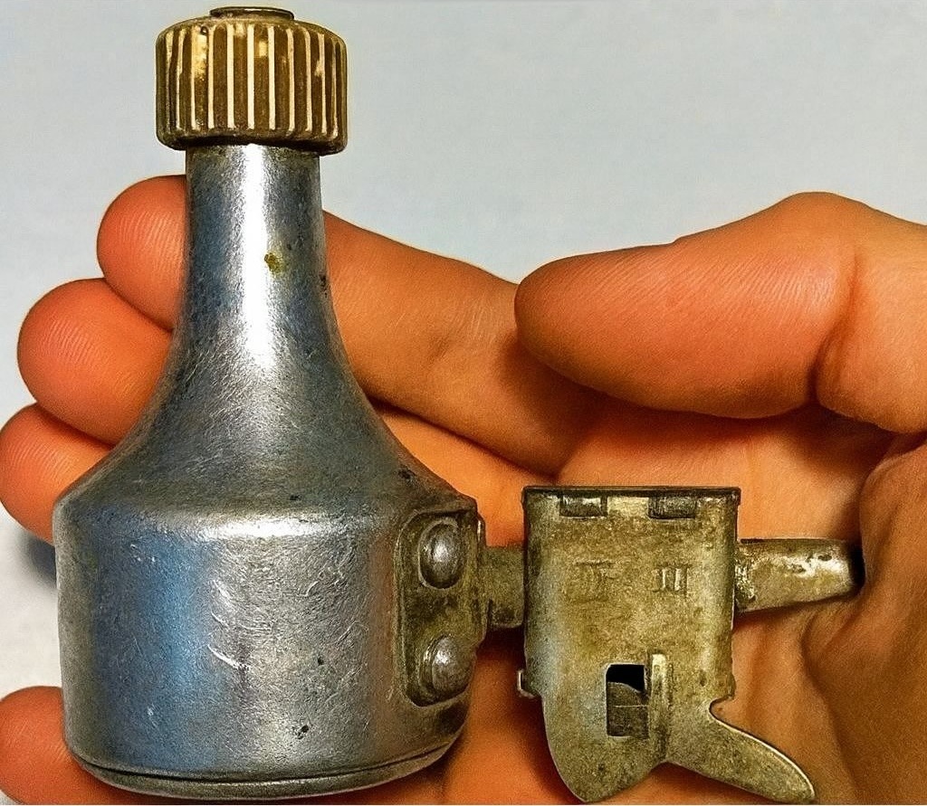 Collection d'objets vintage rouillés trouvés en extérieur, dont une dynamo, posés sur une surface en bois.