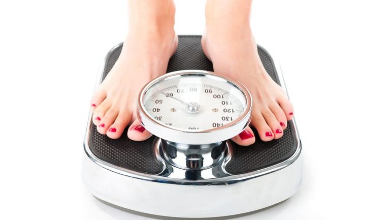 Personne mesurant son tour de taille avec un mètre ruban