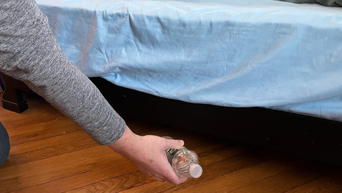 Chambre d'hôtel moderne avec un lit et une bouteille d'eau à proximité