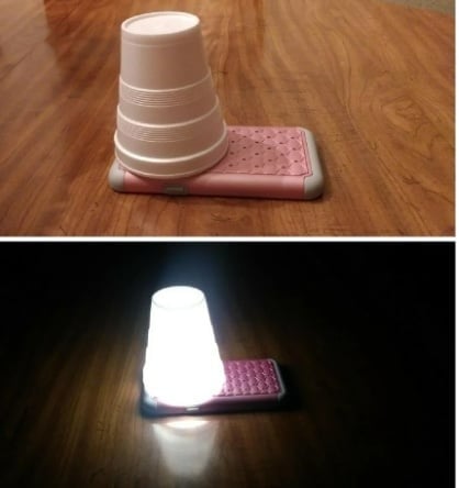 Lampe improvisée avec un gobelet et la lumière d'un téléphone