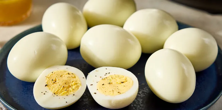 Personne tenant un œuf dur avec une expression de doute