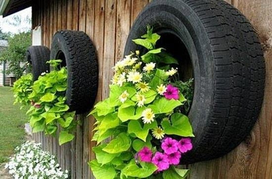 Pneus peints et empilés utilisés comme pots de fleurs