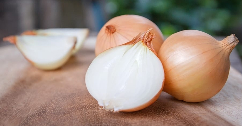Oignons rouges et jaunes sur un plan de travail en bois