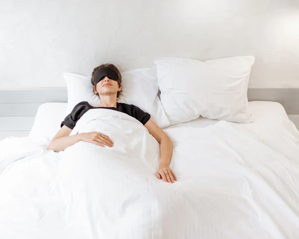 Personne allongée sur le dos, bien alignée, avec un oreiller sous la tête