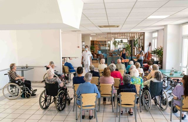 Une personne âgée tenant la main d'un proche dans un intérieur lumineux