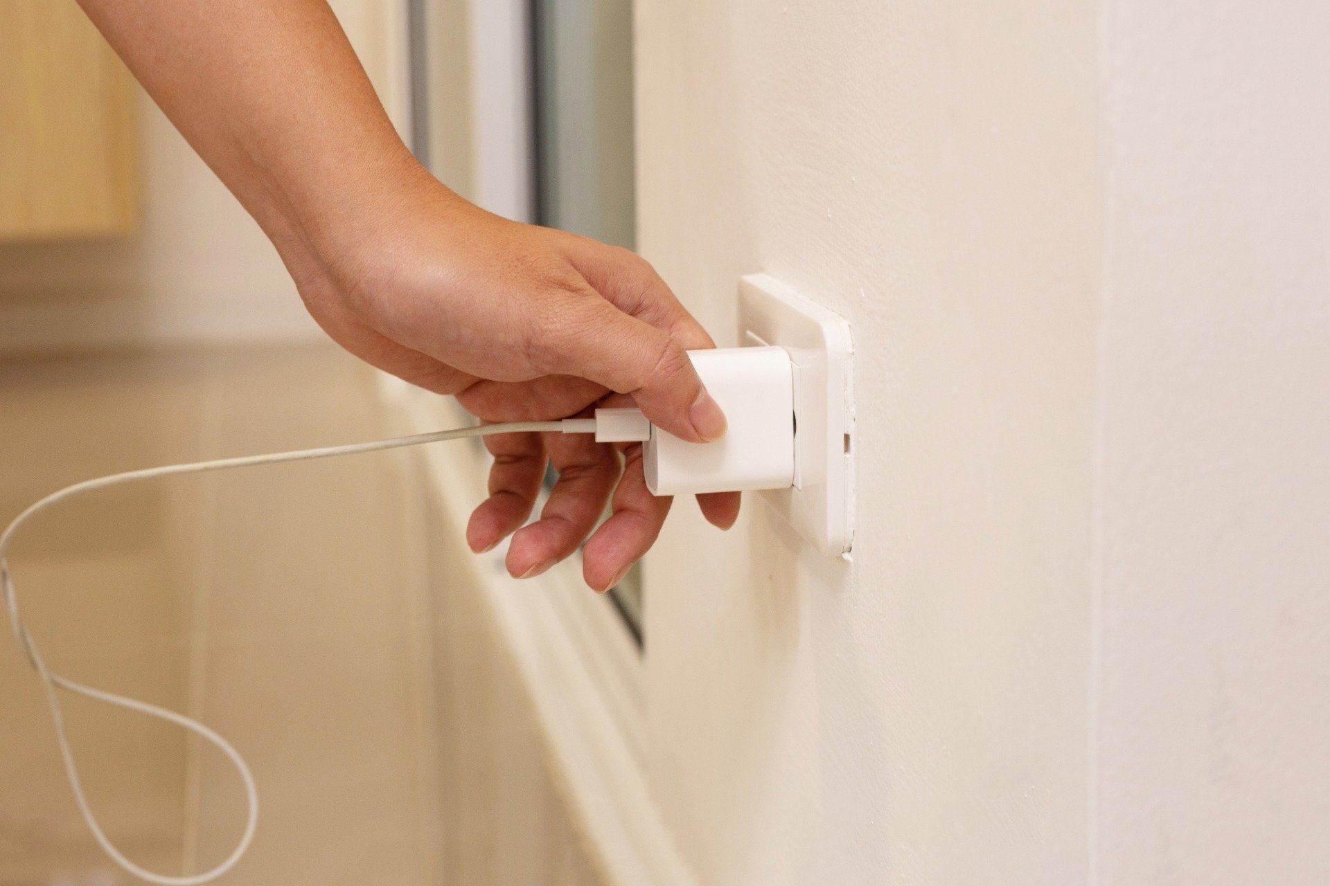 Personne débranchant un chargeur avec un sourire