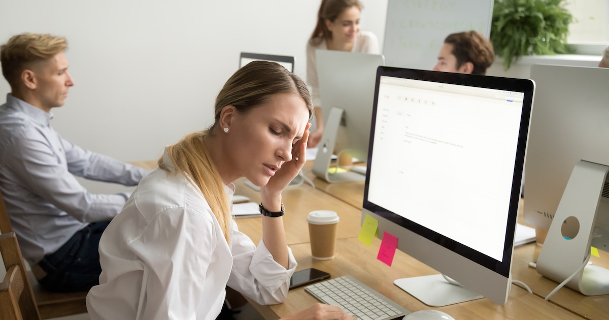Femme stressée, les mains sur la tête, symbolisant la charge mentale