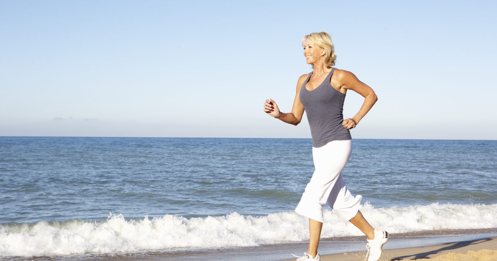 Femme souriante faisant du yoga en extérieur