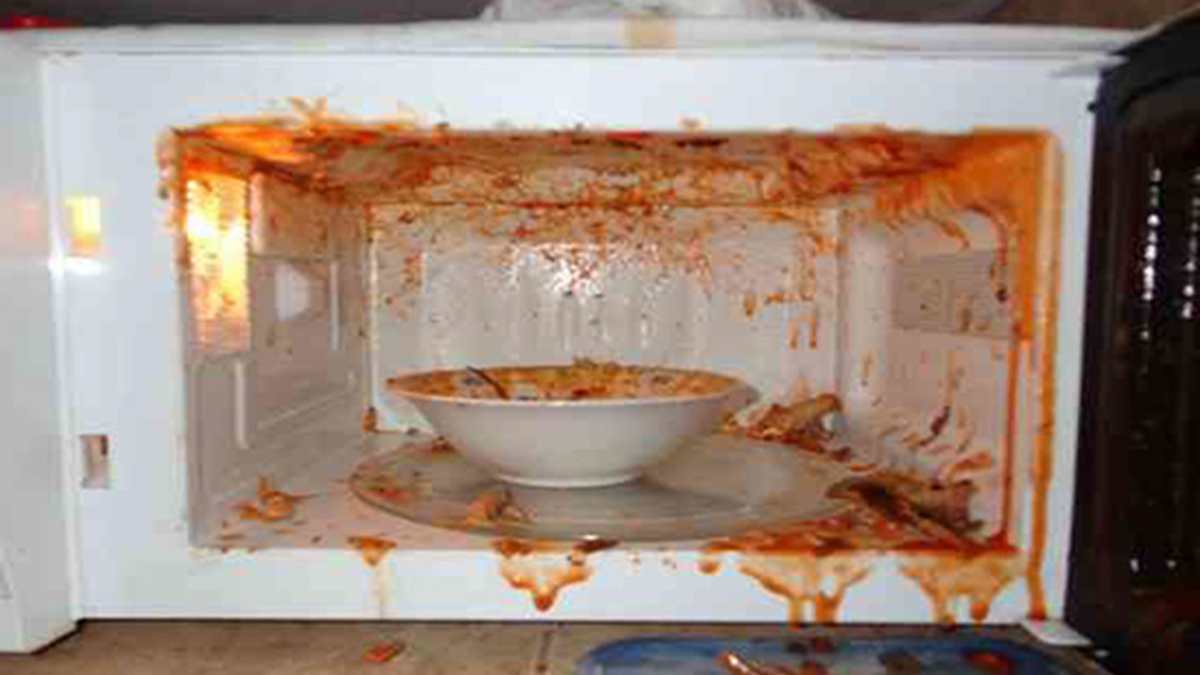 Micro-ondes avec des éclaboussures de nourriture sur les parois