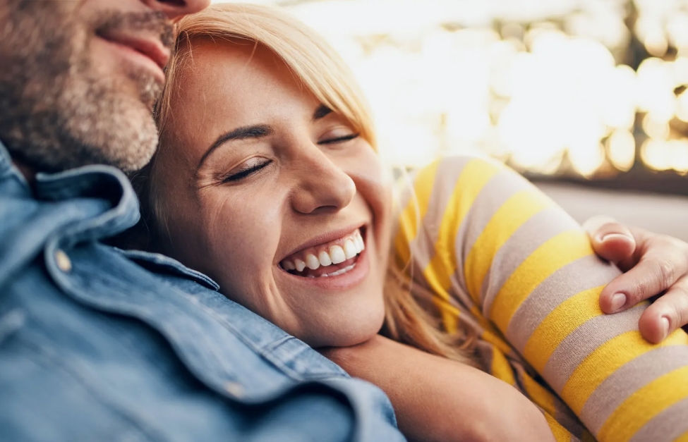 Une salle de bal, les gens debout et applaudissent en direction d'une femme émue