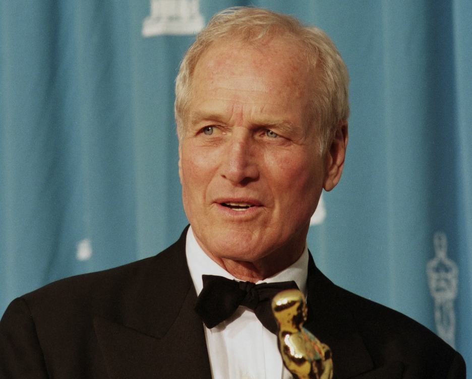 Paul Newman de profil, l'air pensif, en costume clair