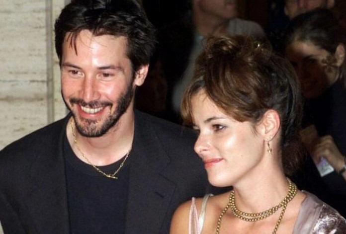 Keanu Reeves en conversation avec une personne, air attentif