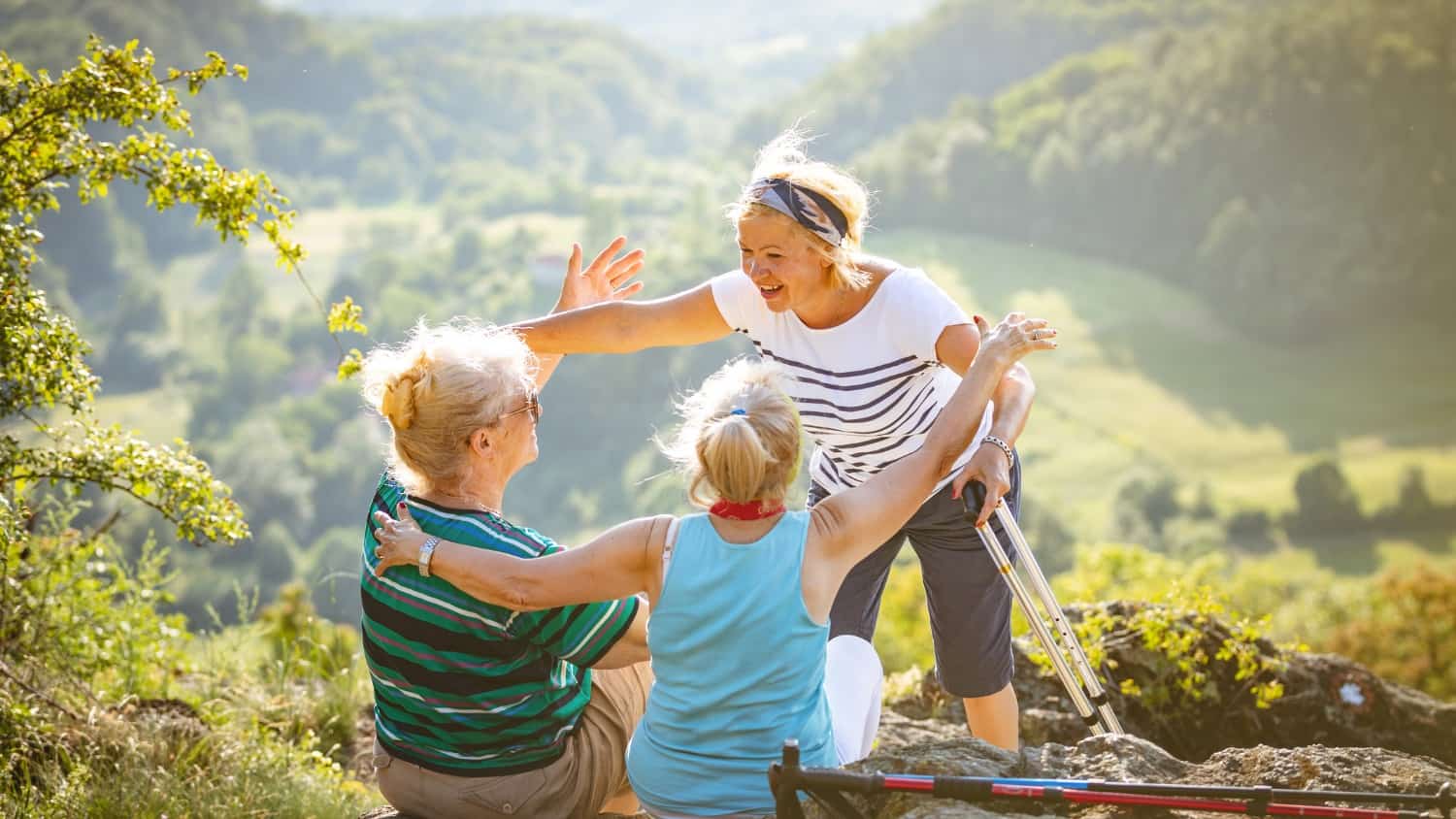 Deux femmes d'âge mûr discutant et riant ensemble sur un canapé, illustrant le soutien et la complicité.