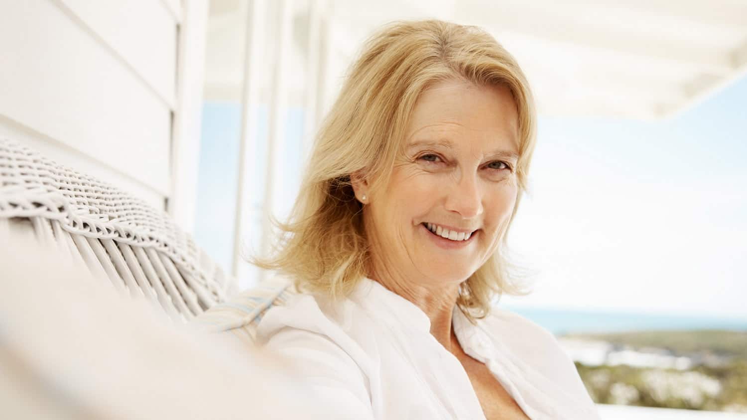 Femme souriante et épanouie, les bras ouverts, symbolisant la liberté et la redécouverte de soi.