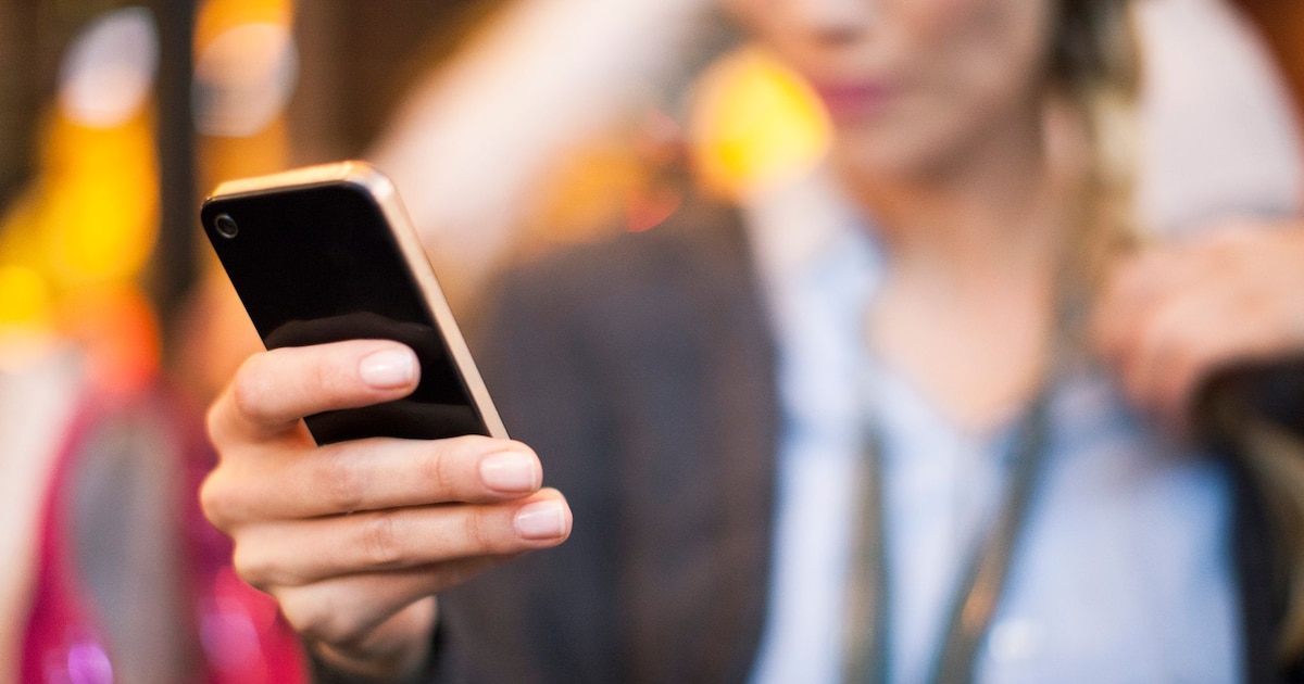 Téléphone portable posé sur une table, écran allumé indiquant un appel entrant