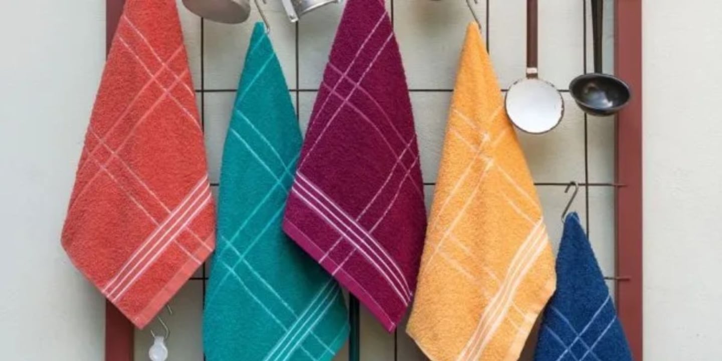 Torchons de cuisine empilés sur un plan de travail en bois