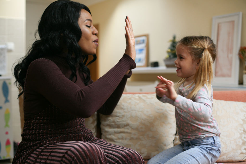 Femme afro-américaine accompagnant un enfant dans une activité quotidienne