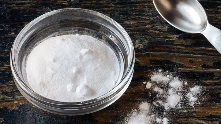 Pot de bicarbonate de soude et citron sur un plan de travail