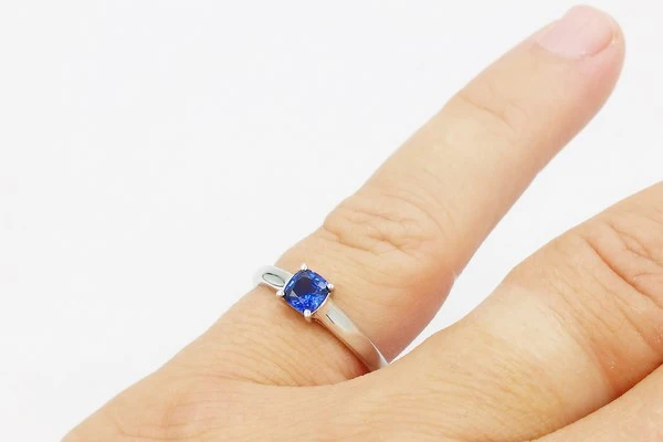 Bague ornée d'un saphir portée sur l'auriculaire d'une femme