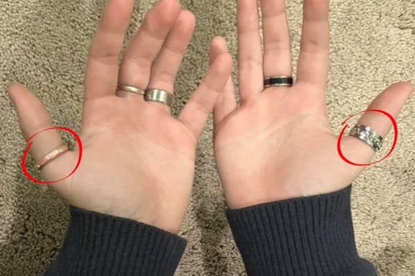 Deux mains portant des bagues rouges au pouce