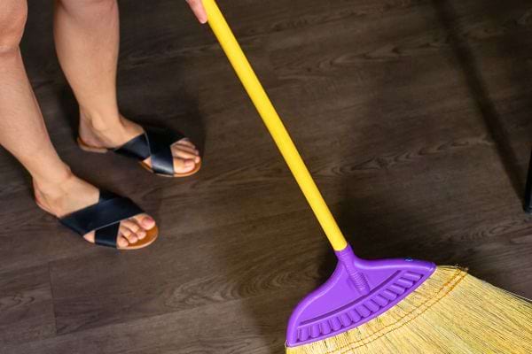 Balai jaune posé sur le sol d'un intérieur propre