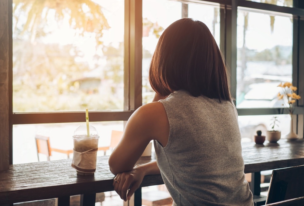 Femme souriante prenant un café seule en terrasse