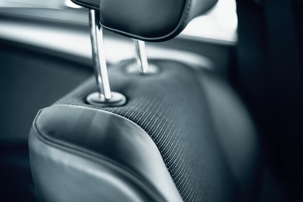 Personne réglant l'appuie-tête de son siège auto