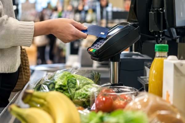 Paiement des courses par carte bancaire à la caisse d'un supermarché.