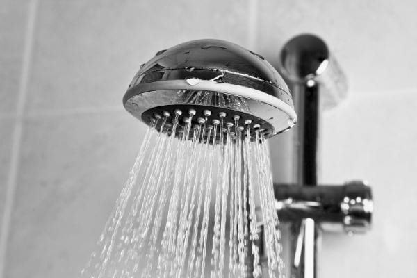 Pommeau de douche mural laissant couler un jet d'eau.
