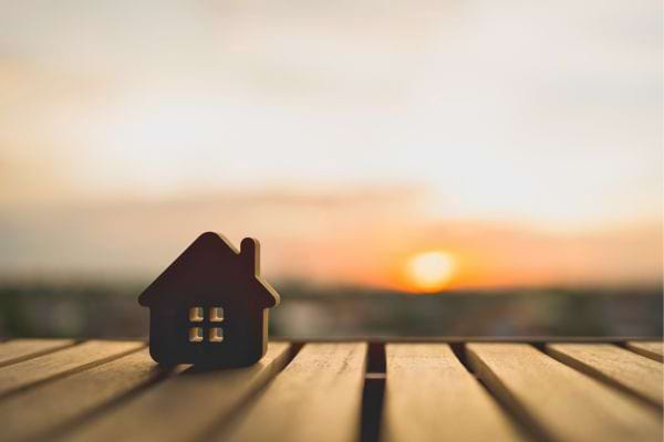 Maison miniature sur table au coucher du soleil.