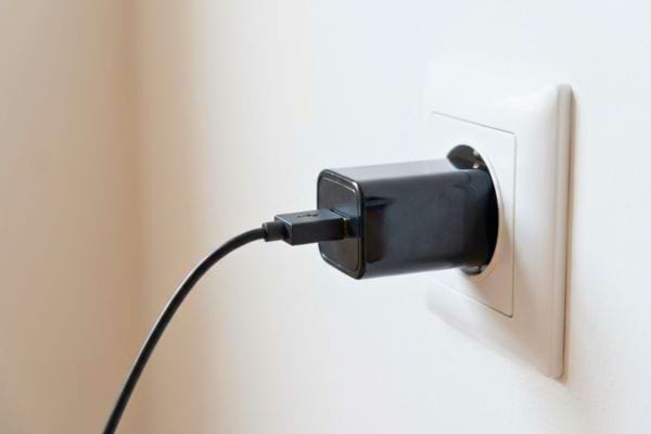 Chargeur branché à une prise murale avec câble USB connecté