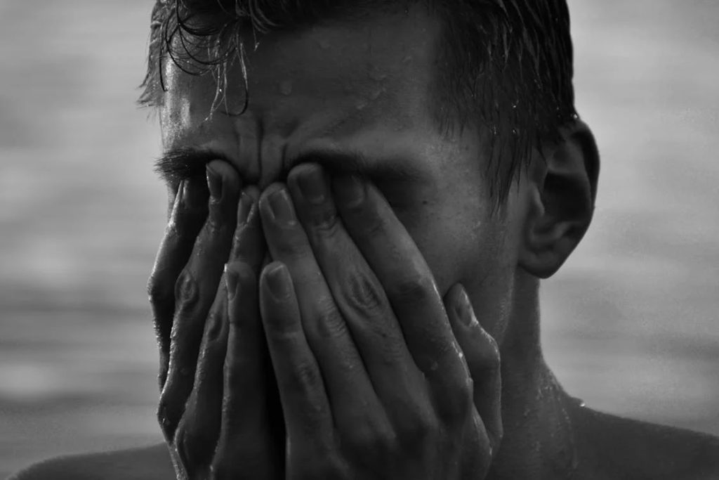 Wet Man Covering His Face with His Hands