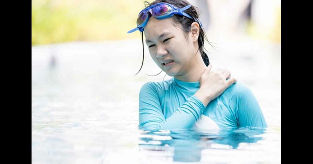 Asian teen girl having itchy or irritated skin,dry skin problem,scratching her body in swimming pool