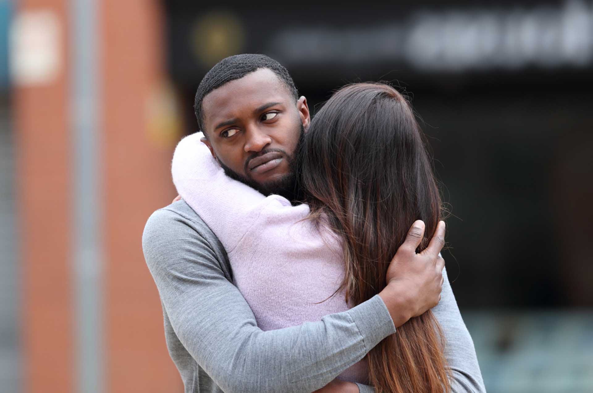 Couple assis dos à dos, semblant distant et perdu dans ses pensées