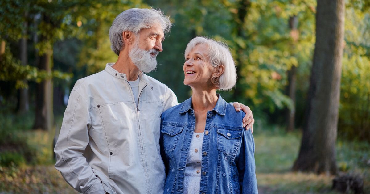 Couple d'un certain âge se tenant la main, regard pensif