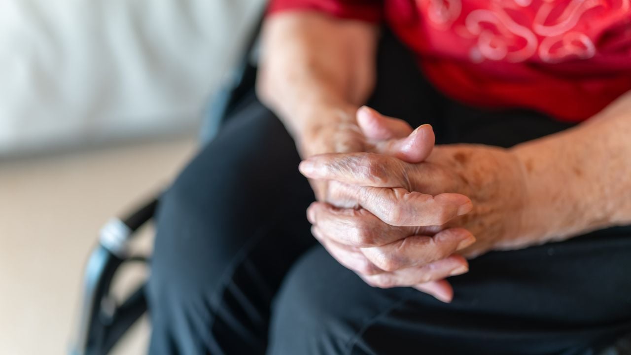 Photo d'une personne âgée tenant la main d'un proche, symbolisant les relations et la fragilité de la vie