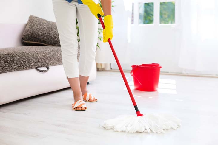 Sol propre et brillant après nettoyage, avec une éponge posée à côté.