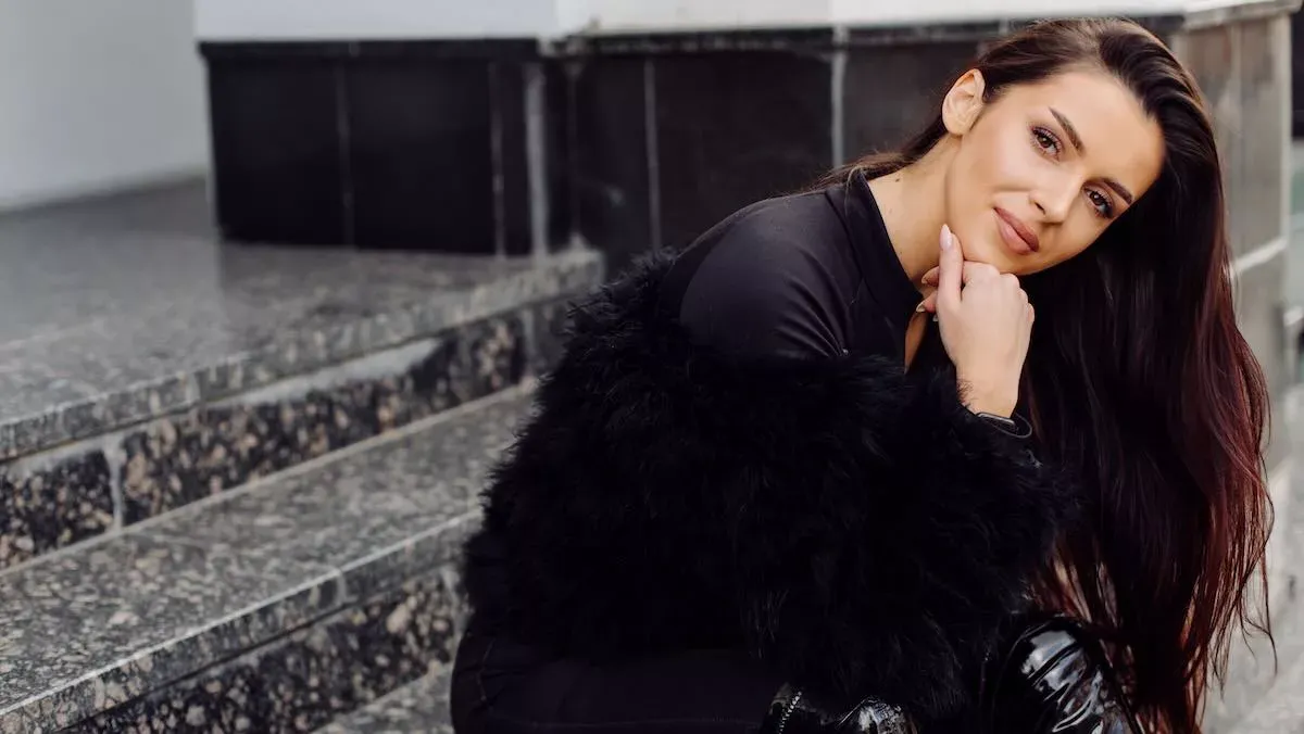 Femme élégante vêtue de noir, assise dans un intérieur moderne